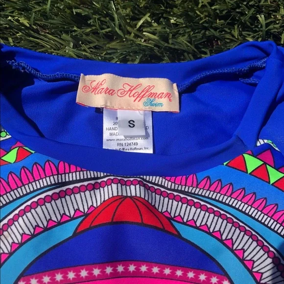 Mara Hoffman rash guard with pink ganesh against a pool blue background